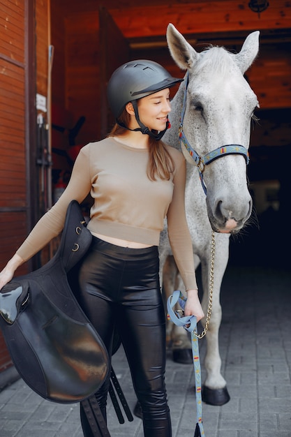Красивая женщина, стоящая с лошадью