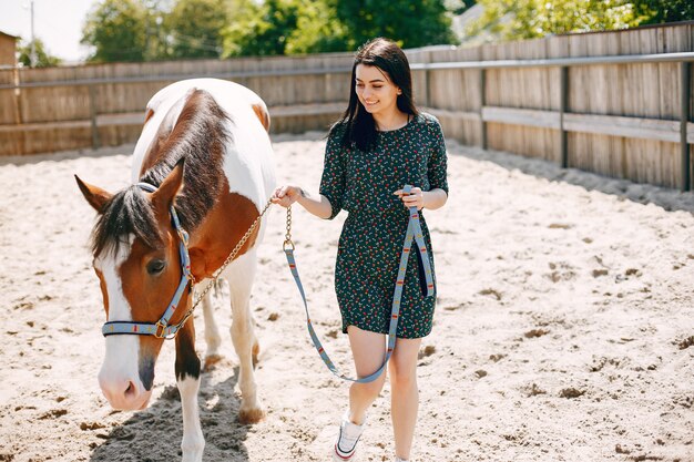 Beautiful woman standing with a horse