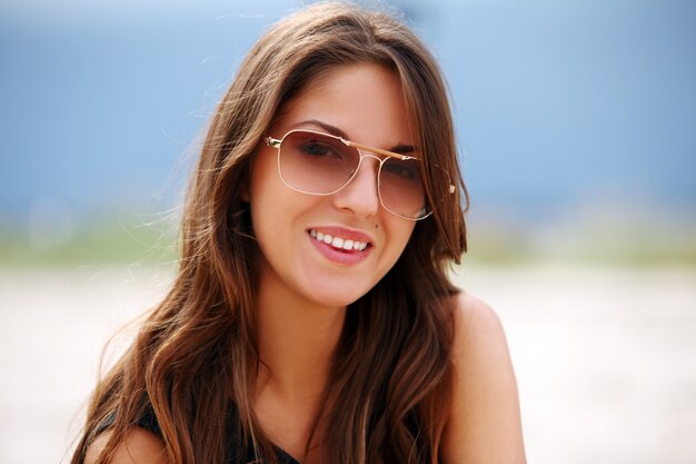 Beautiful woman in sunglasses on the beach