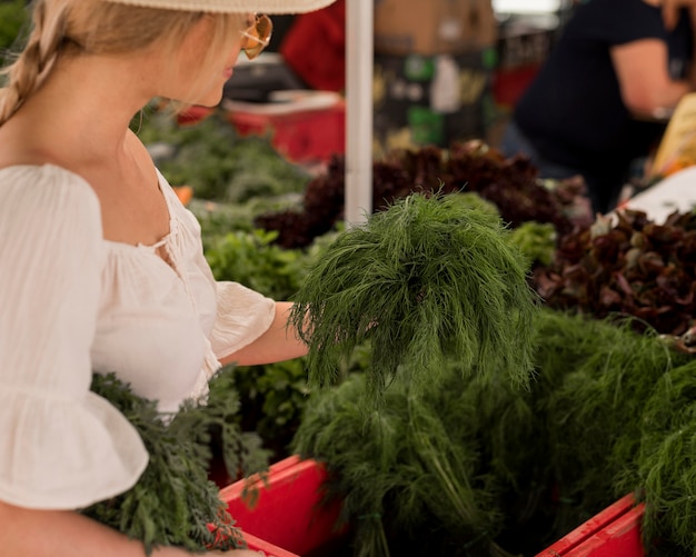 Beautiful woman taking dill leaves