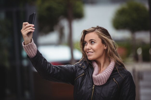 스마트 폰 selfie를 복용하는 아름 다운 여자