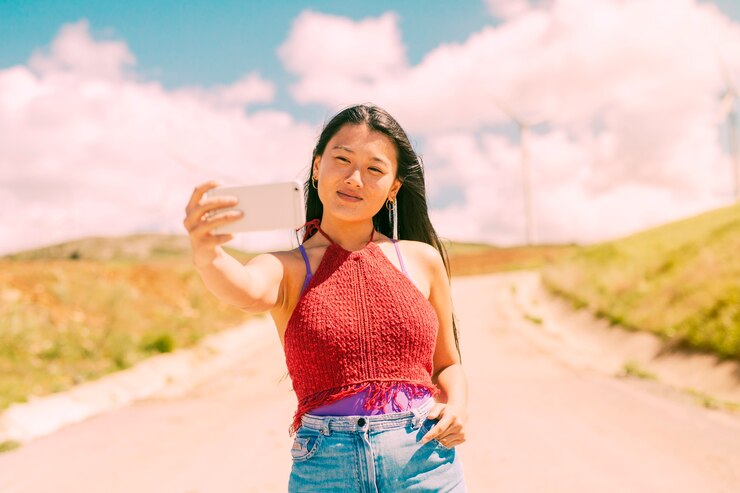 無料Photo スマートフォンでselfieを取っている美しい女性