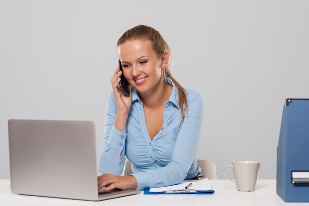 Beautiful woman talking on mobile phone during the office work