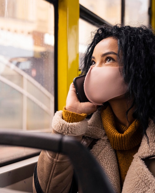 Beautiful woman talking on the phone in the bus