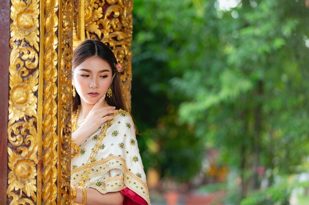 태국 전통 복장 미소하고 사원에 서있는 아름다운 여자
