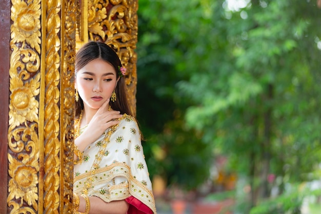 태국 전통 복장 미소하고 사원에 서있는 아름다운 여자