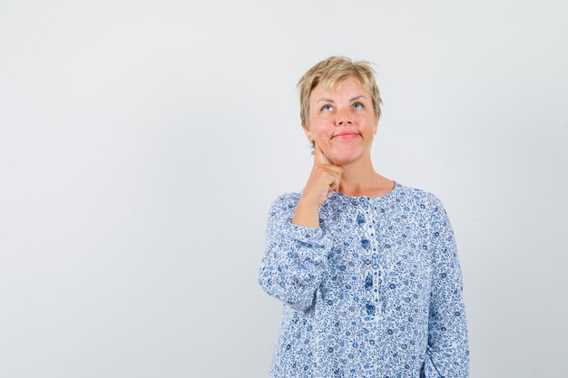 Beautiful woman thinking something in patterned blouse front view. space for text