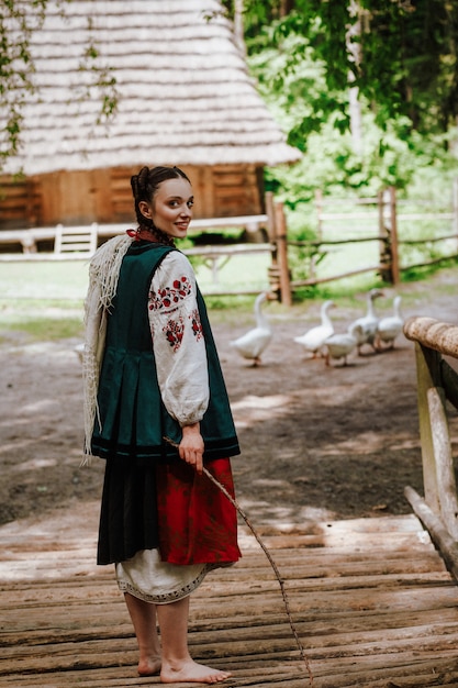 Красивая женщина в традиционном вышитом платье гуляет босиком