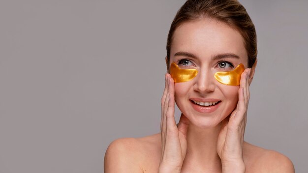 Beautiful woman using under eye patch masks