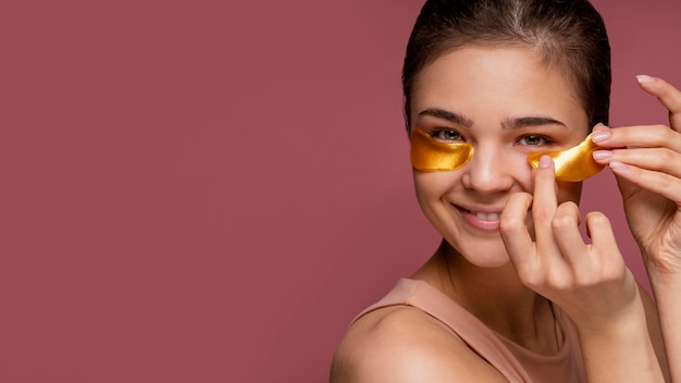 Beautiful woman using under eye patch masks