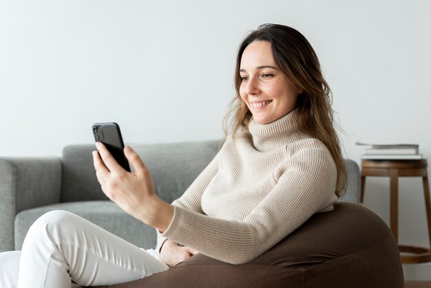 Beautiful woman using smartphone on a bean bag