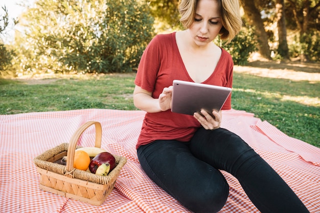 無料写真 ピクニックにタブレットを使用している美しい女性