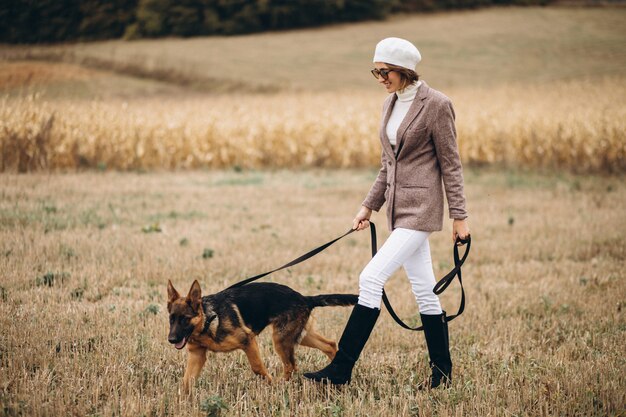 Beautiful woman walking out her dog in a field