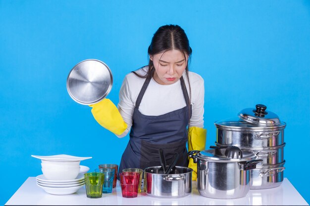 a beautiful woman washing dishes in front of him on a blue .