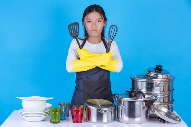 A beautiful woman washing dishes in front of him on a blue