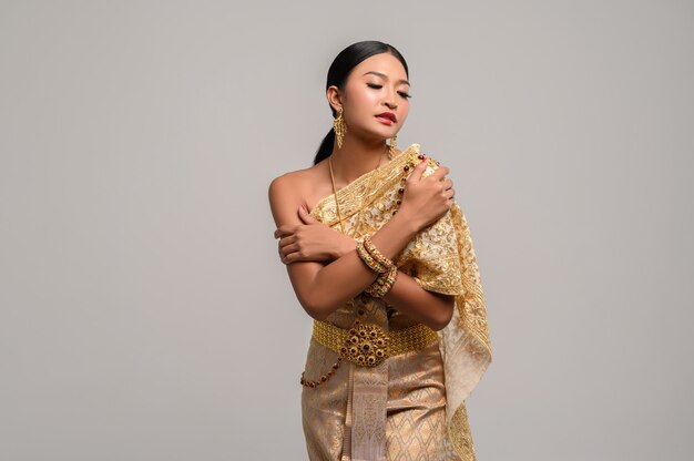 Beautiful woman wear Thai clothes and stand to hug her breasts.