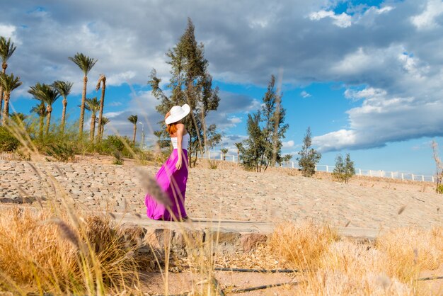 Beautiful woman wearing hat and pink skirt