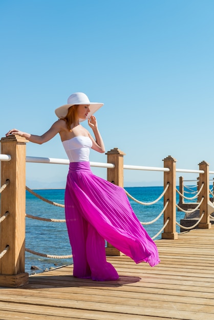 Beautiful woman wearing hat and pink skirt