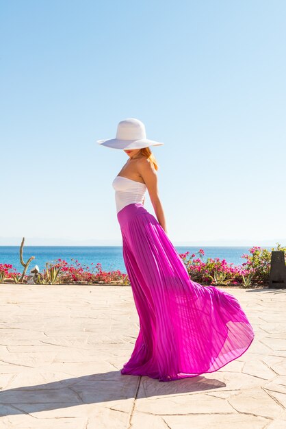 Beautiful woman wearing hat and pink skirt