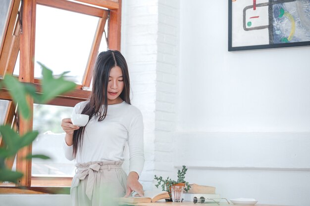 Beautiful woman wearing a long-sleeved white shirt sitting at a coffee shop