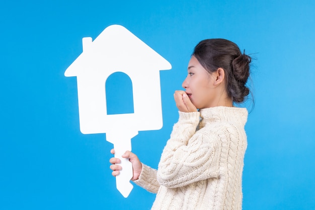 A beautiful woman wearing a new long sleeved white shirt with a house symbol  . House trading .