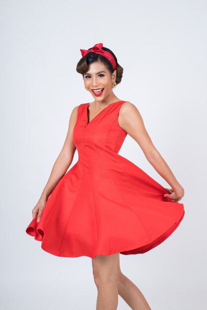 Beautiful woman wearing red dress in studio