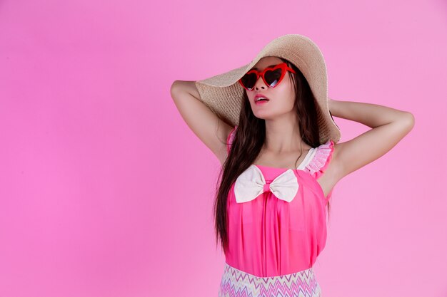 핑크에 큰 모자와 빨간 안경을 쓰고 아름 다운 여자.