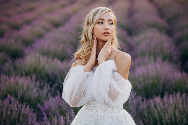 Beautiful woman in wedding dress in lavender field