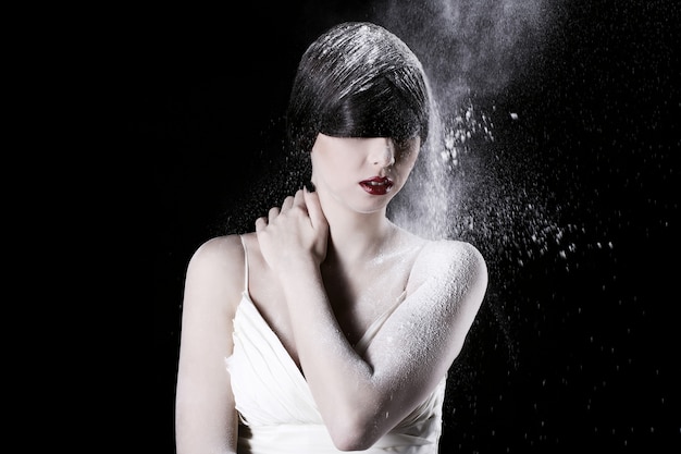 Beautiful woman in white dress and flying dust