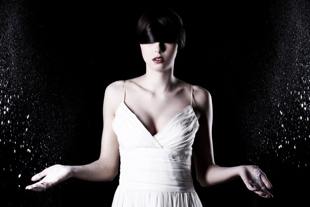 Beautiful woman in white dress and flying dust