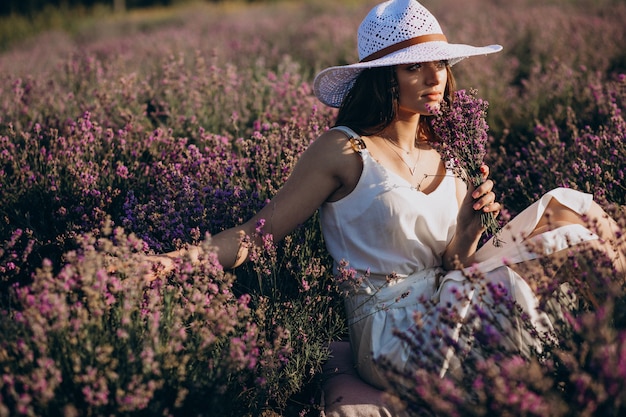 Bella donna in abito bianco in un campo di lavanda