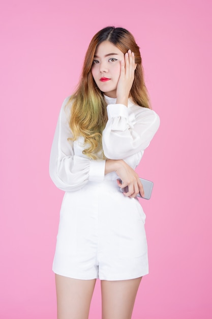 Beautiful woman, white dress showing the phone and the mood of the face