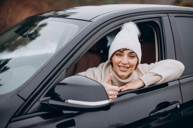 Beautiful woman in winter coat sitting in car