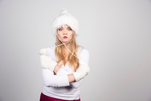 Beautiful woman in winter outfit playing with hat.