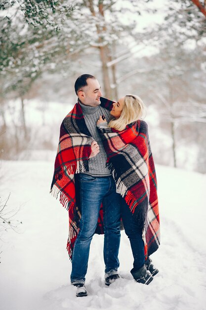 Beautiful woman in a winter park with her husband
