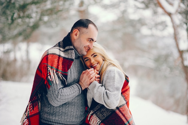 Beautiful woman in a winter park with her husband