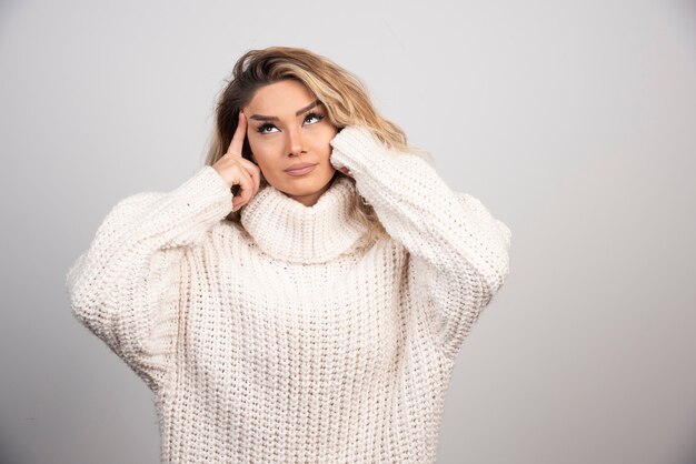 Beautiful woman in winter sweater thinking about something. 