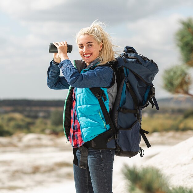 Beautiful woman with backpack and binoculars