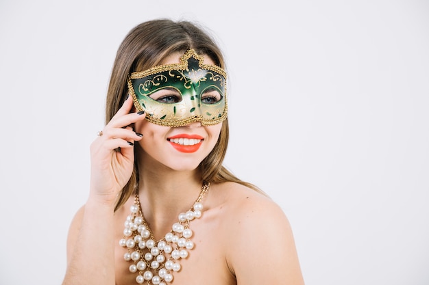 Бесплатное фото Красивая женщина с бисером ожерелье и карнавальная маска на белом фоне