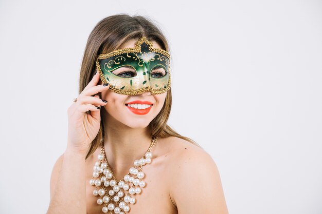 Красивая женщина с бисером ожерелье и карнавальная маска на белом фоне