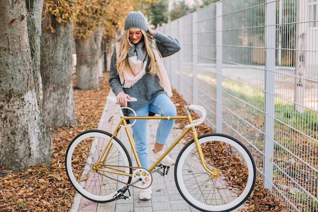 フェンスの近くの自転車で美しい女性