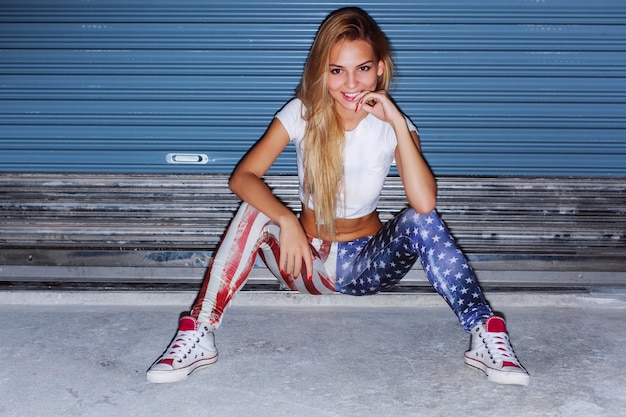 Free photo beautiful woman with a big smile wearing american flag pants