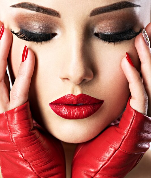 밝은 패션 메이크업과 섹시한 입술에 빨간 립스틱을 가진 아름 다운 여자. 근접 촬영 초상화.