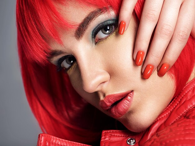 Beautiful woman with bright red nails.  Portrait of an attractive girl with bob hairstyle. Fashion  model.  Gorgeous girl wears leather jacket. Sexy face of a pretty lady.