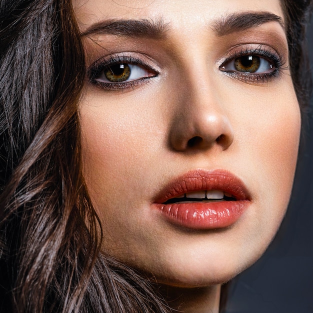 Beautiful woman with  brown eyes. Fashion model with a smokey makeup. Closeup portrait of a pretty woman looks at camera.