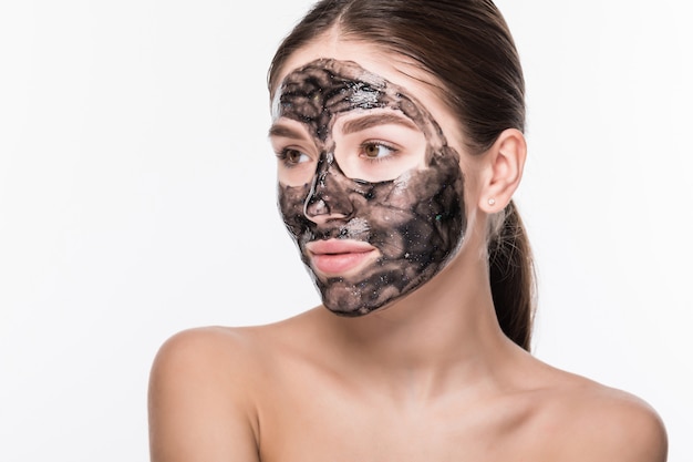Foto gratuita bella donna con un'argilla o una maschera di fango sul suo viso isolato sul muro bianco