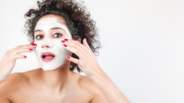 Beautiful woman with facial mask isolated on white background