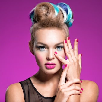 Beautiful woman with fashion hairstyle and pink nails.  fashion portrait of young caucasian model with bright makeup.  fashion makeup.  closeup portrait. gorgeous face of an attractive girl - studio.