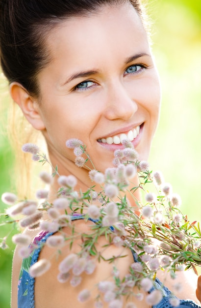 Foto gratuita bella donna con pianta di campo nelle mani