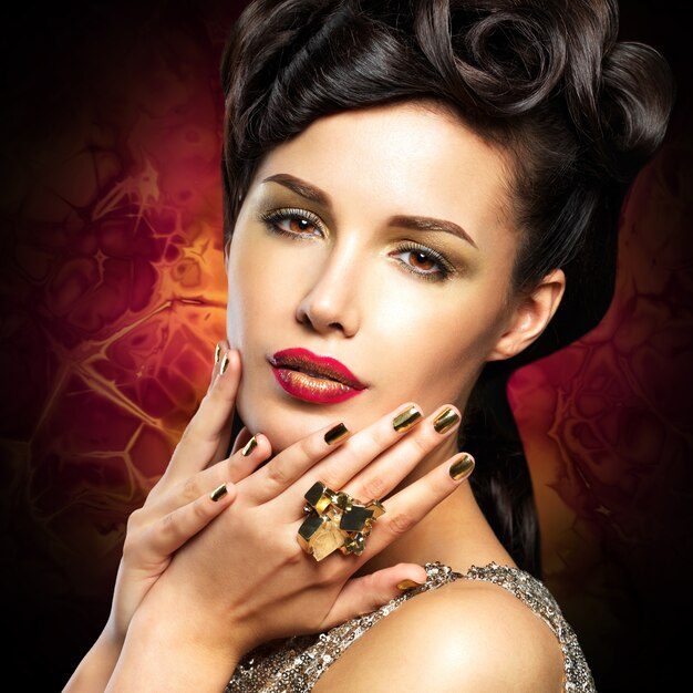 Beautiful  woman with golded nails and bright red lips